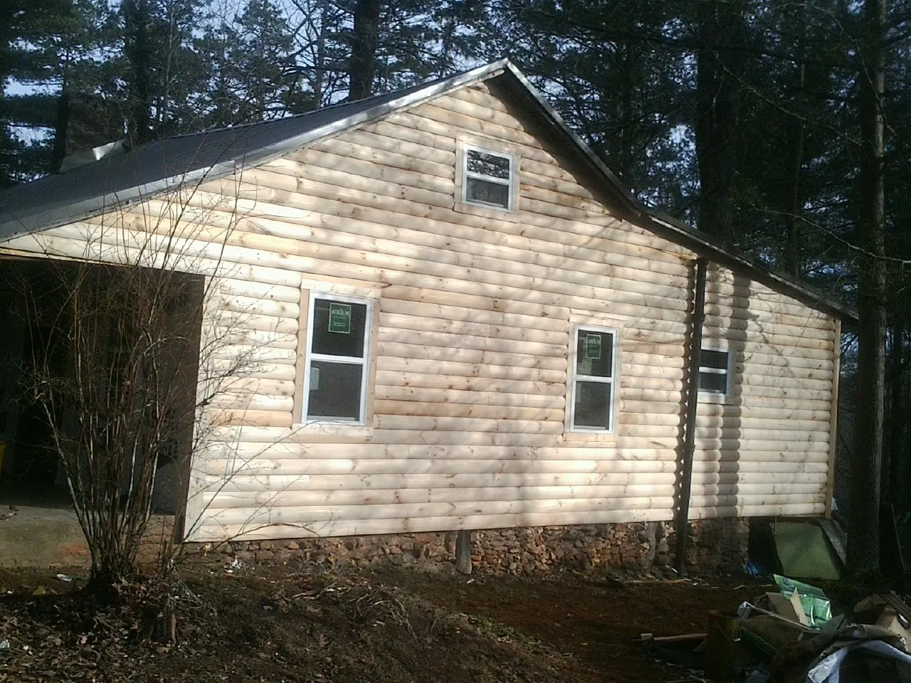 New log siding and dark metal roofing on a gable end in Woodbridge