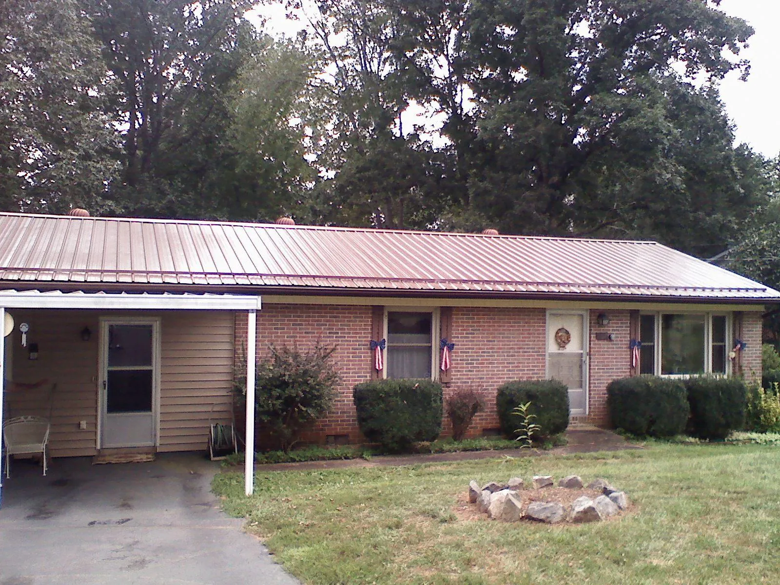 Bronze metal roof and carport on a brick ranch home — Roof Repair work by our crew in Woodbridge